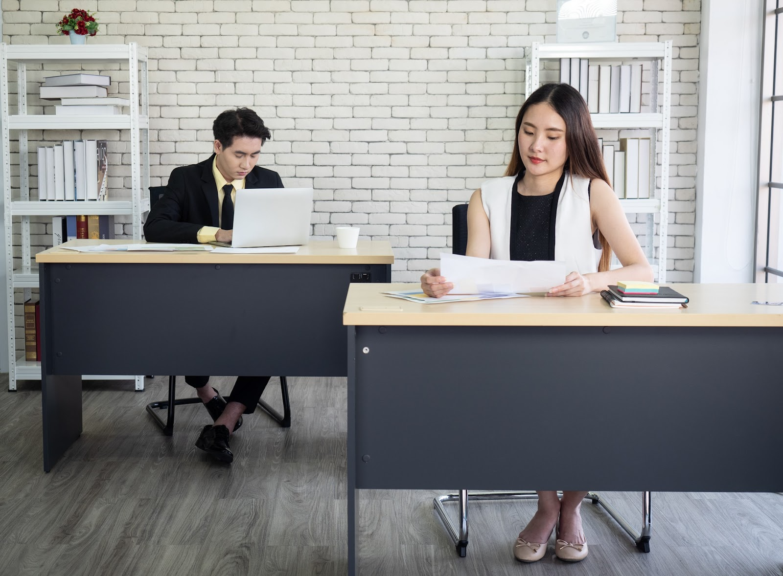 Two people sitting at desks looking at papers