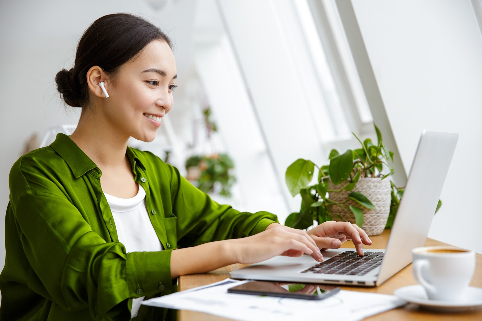 Woman with earplugs using her laptop